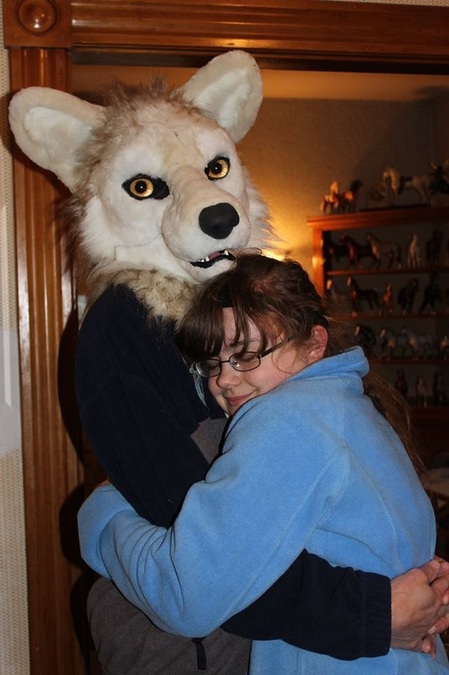 husband wearing unpainted fursuit wolf head hugging daughter