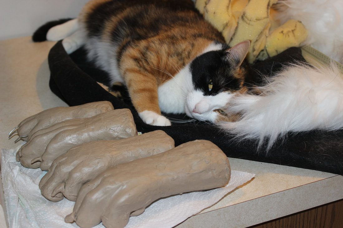 clay model for a fursuit handpaw and a cat